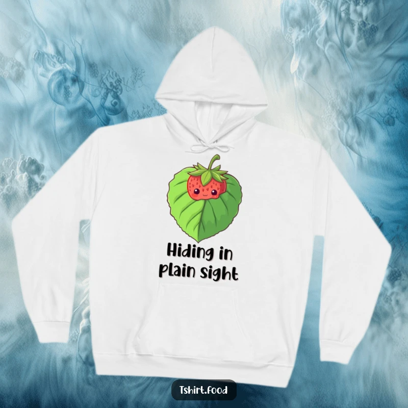 Funny hoodie featuring a shy strawberry peeking from behind a large leaf, designed for ultimate coziness and charm.